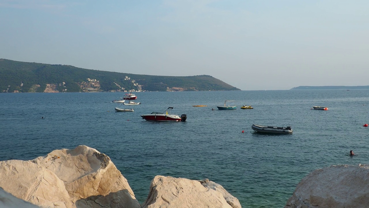 海上度假旅行。小船漂浮在亚得里亚海上。地中海旅游业务。帆船和山脉。咸水上的小涟漪。阳光明媚的天气。石头和石头。视频素材