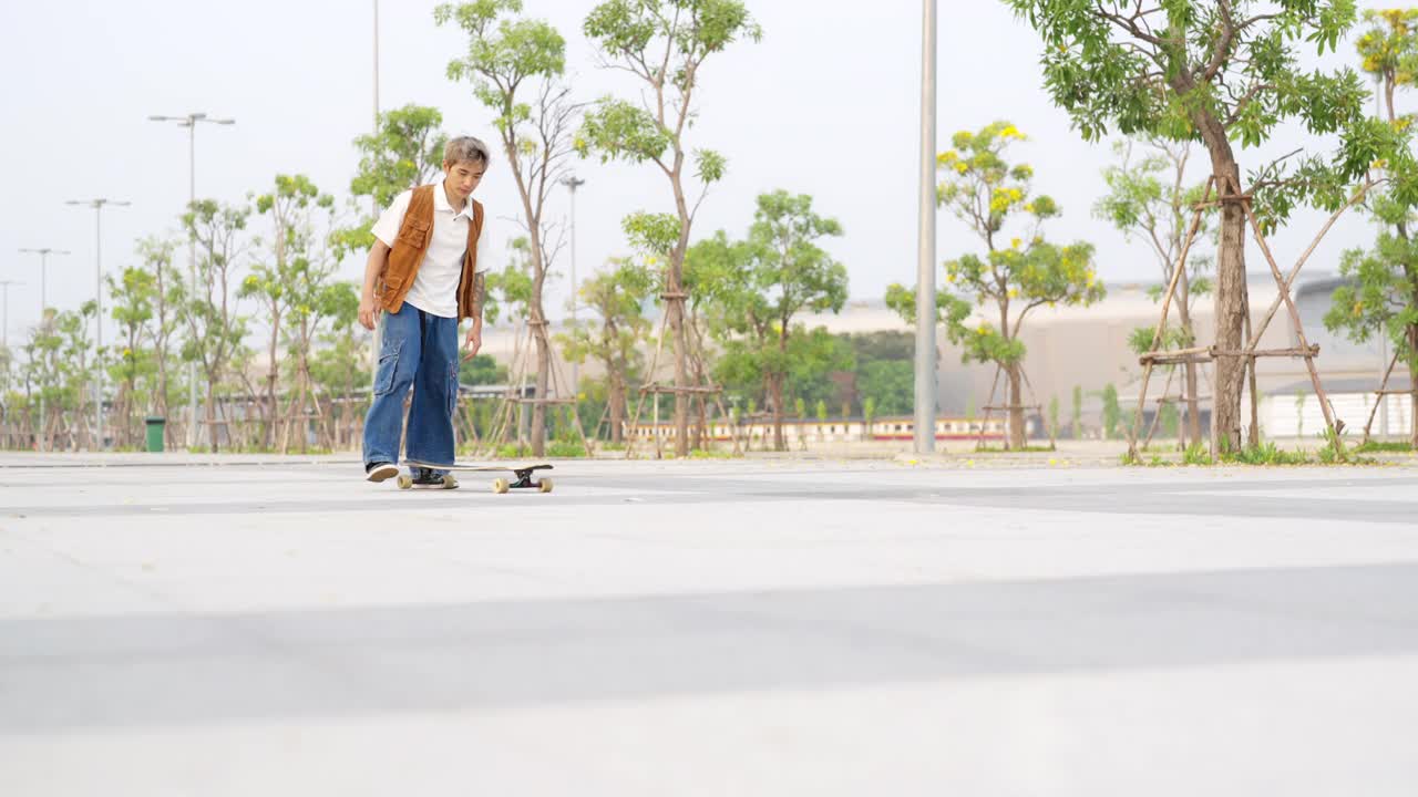 4K亚洲男子在公园滑长板溜冰在夏天的日落。视频素材