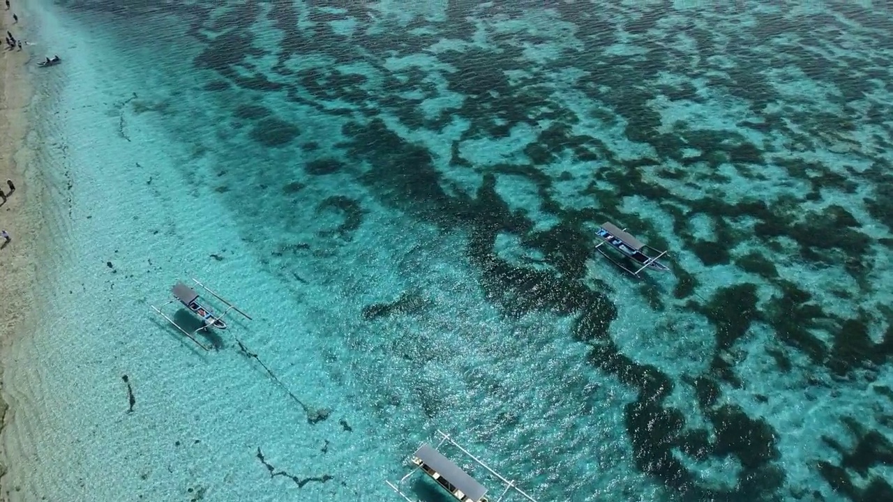 在天堂岛透明的海洋和海滩上的渔船。鸟瞰图。视频素材