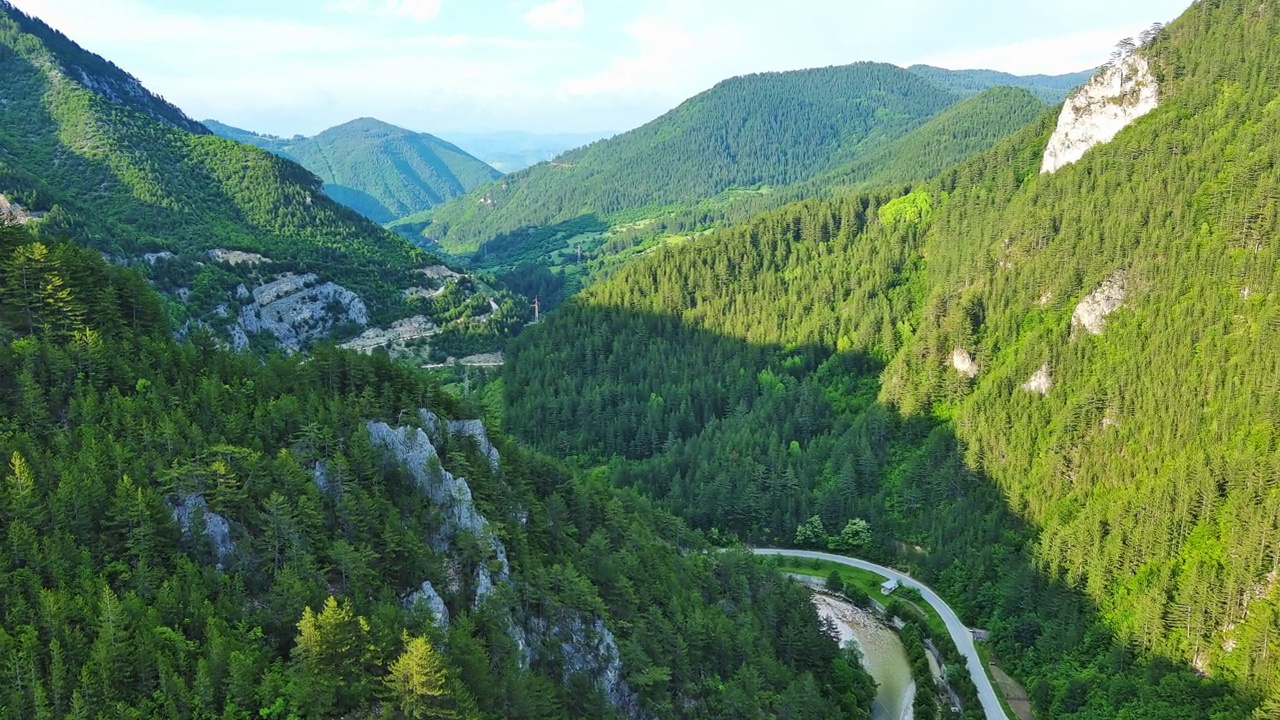 在Rhodope山脉的白天，一条蜿蜒的道路穿过长满树叶的山谷视频素材