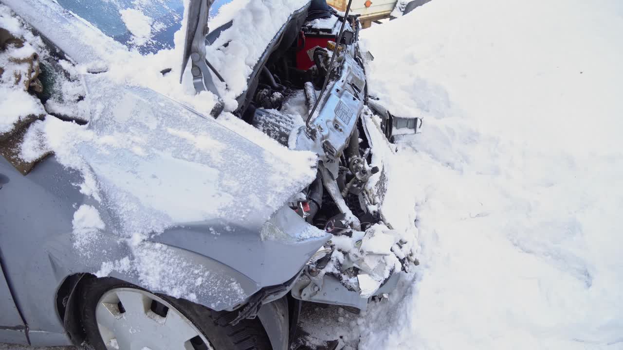 道路交通事故中有汽车，雪地中有汽车撞车，冬季道路上有事故，车辆被毁。汽车正面碰撞视频素材