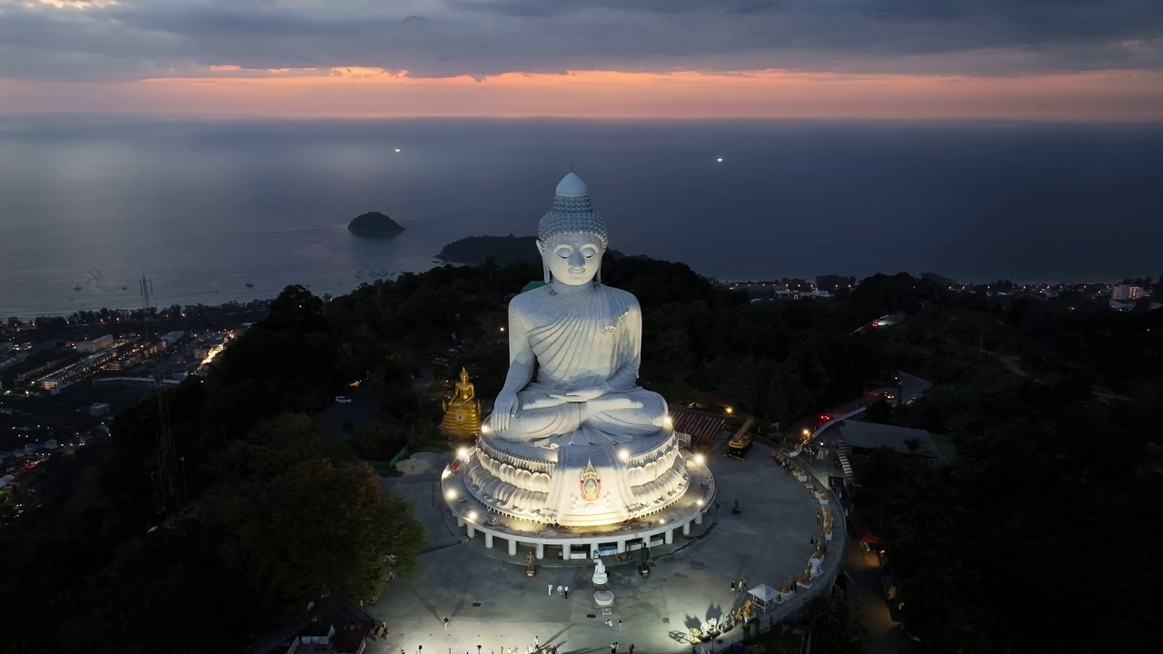 白色大理石大佛雕像寺庙，近距离鸟瞰泰国普吉岛山顶大佛，令人惊叹的日落或日出天空在海上视频素材