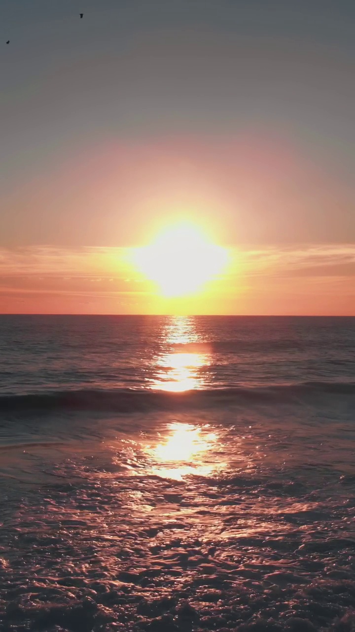 海水上金色的夕阳。太阳在五彩缤纷的天空中落下。垂直视频视频素材