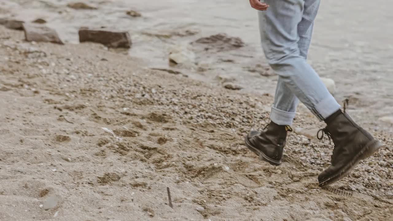 孤独的男孩走在海滩上视频素材