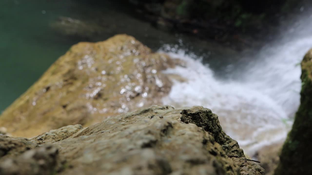 阳光明媚的日子里，水流在瀑布处，迷离的，pahangg瀑布视频素材