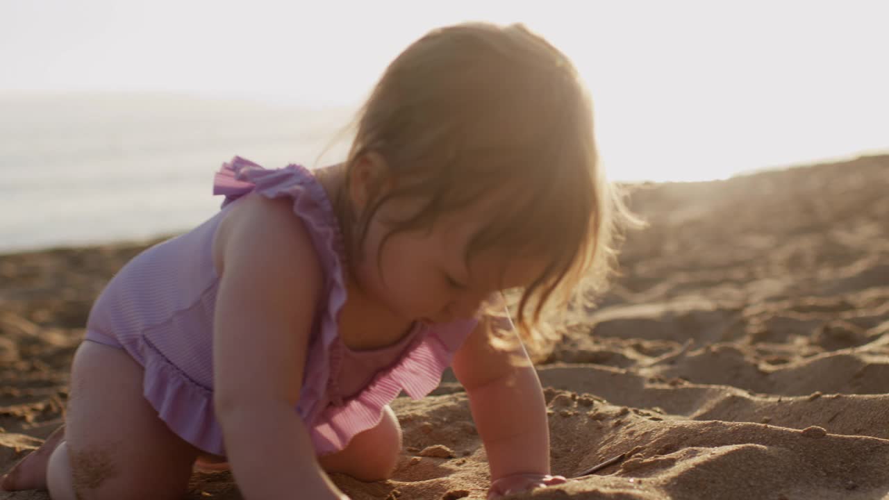 可爱的女婴在海边享受夏日夕阳下的海滩假期视频素材