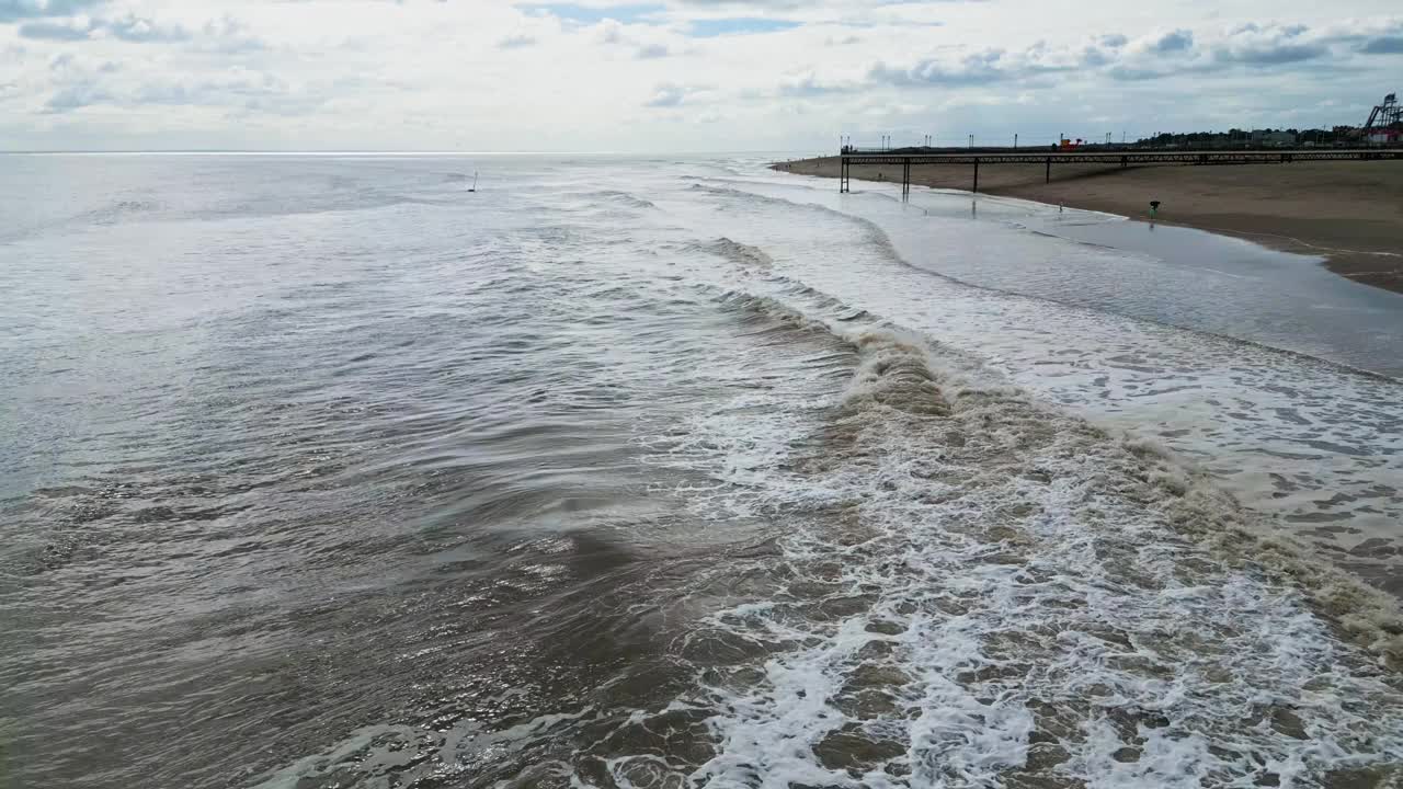 航拍的泡沫海浪冲击沙滩，背景是地平线视频素材