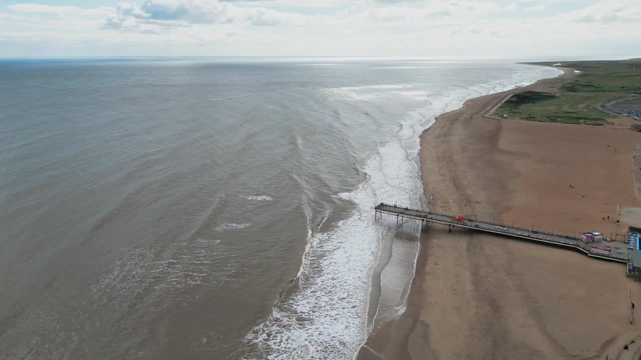 航拍的泡沫海浪冲击沙滩，背景是地平线视频素材