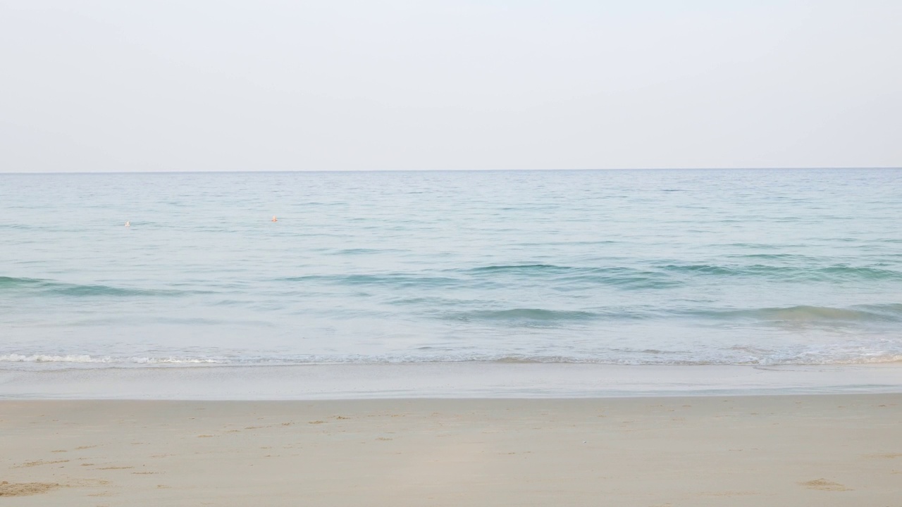 夏天的大海在阳光明媚的日子美丽的热带海滨风景在普吉岛海滩与海浪冲击沙滩，暑假假期背景在4k视频。视频素材