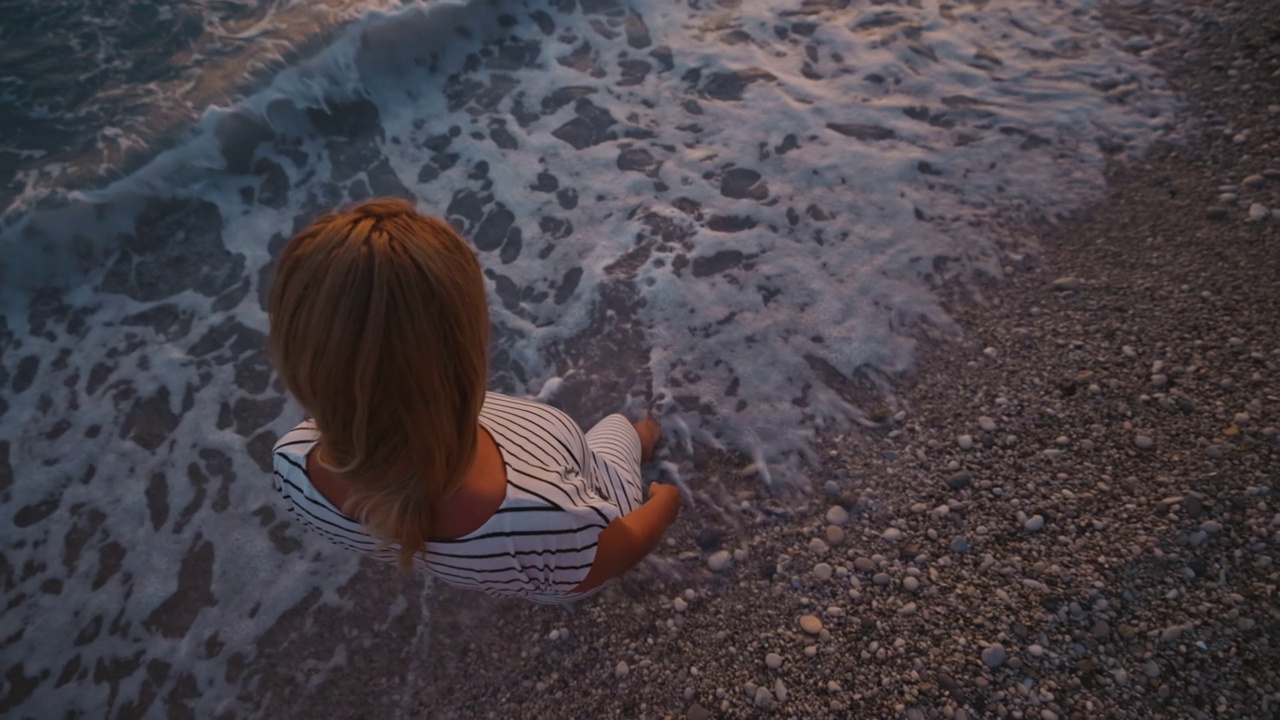 在海岸线上玩海浪的女人视频素材