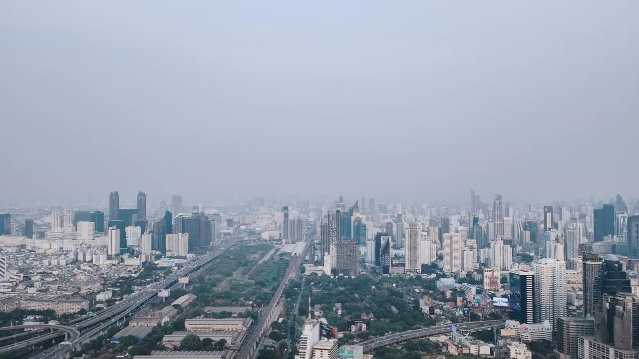 鸟瞰泰国首都曼谷高速公路上拥挤的交通，背景是密集的摩天大楼。视频素材