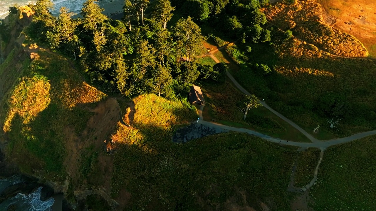 在一个阳光明媚的夏日早晨，当相机在海岸上空盘旋并倾斜时，可以欣赏到可爱的埃科拉州立公园，海底岩石和远处的印度海滩视频下载