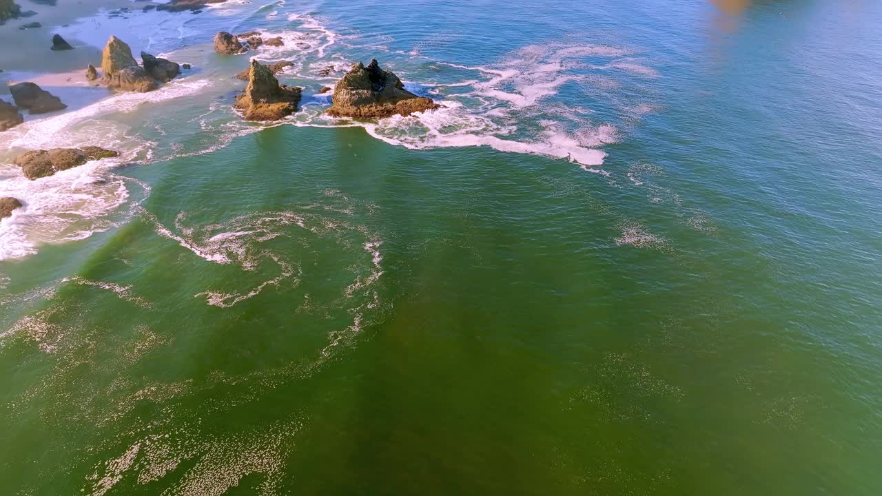 体验海洋之美，相机轻轻飞过，向上倾斜，向后移动，显示惊人的海蚀柱和阳光下的三拱岩。享受明亮的绿色和蓝色的水。视频下载