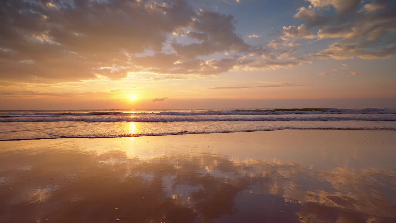 热带海滩的日出，金色的阳光洒在沙滩和海面上视频素材