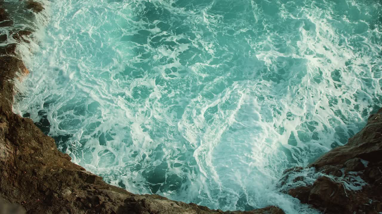 汹涌的海浪特写水白色泡沫的岩石海岸线。视频素材