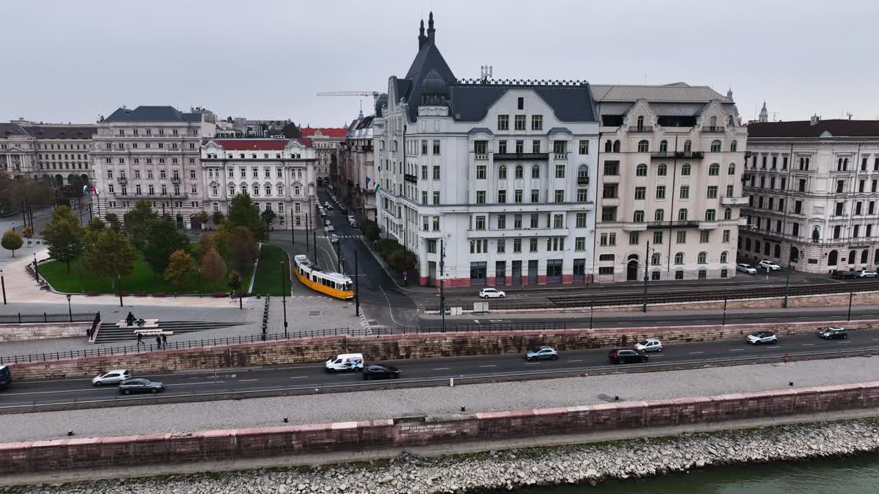 在多云的日子里，典型的布达佩斯有轨电车通过城市街区的鸟瞰图，空中跟踪跟随镜头广角，匈牙利。视频素材