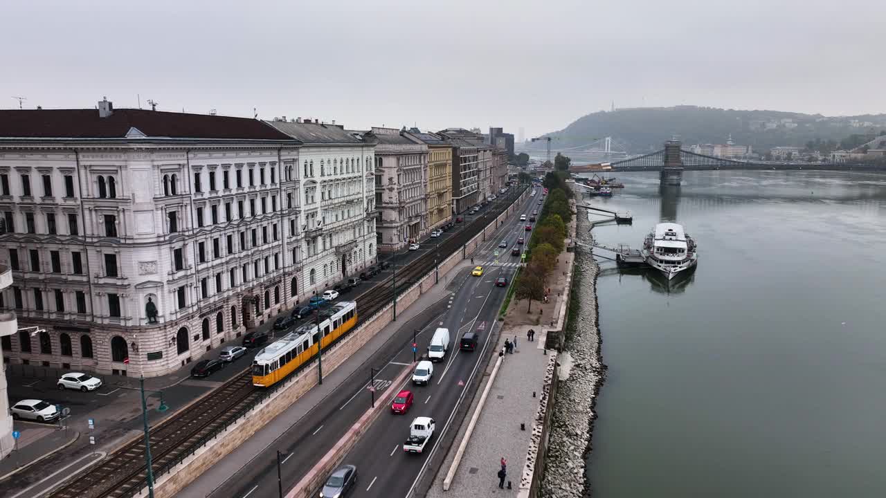 在多云的日子里，典型的布达佩斯有轨电车通过城市街区的鸟瞰图，空中跟踪跟随镜头广角，匈牙利。视频素材