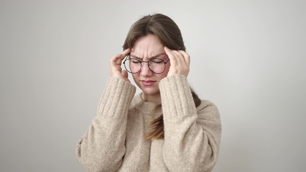 年轻的金发女子强调站在孤立的白色背景上视频素材