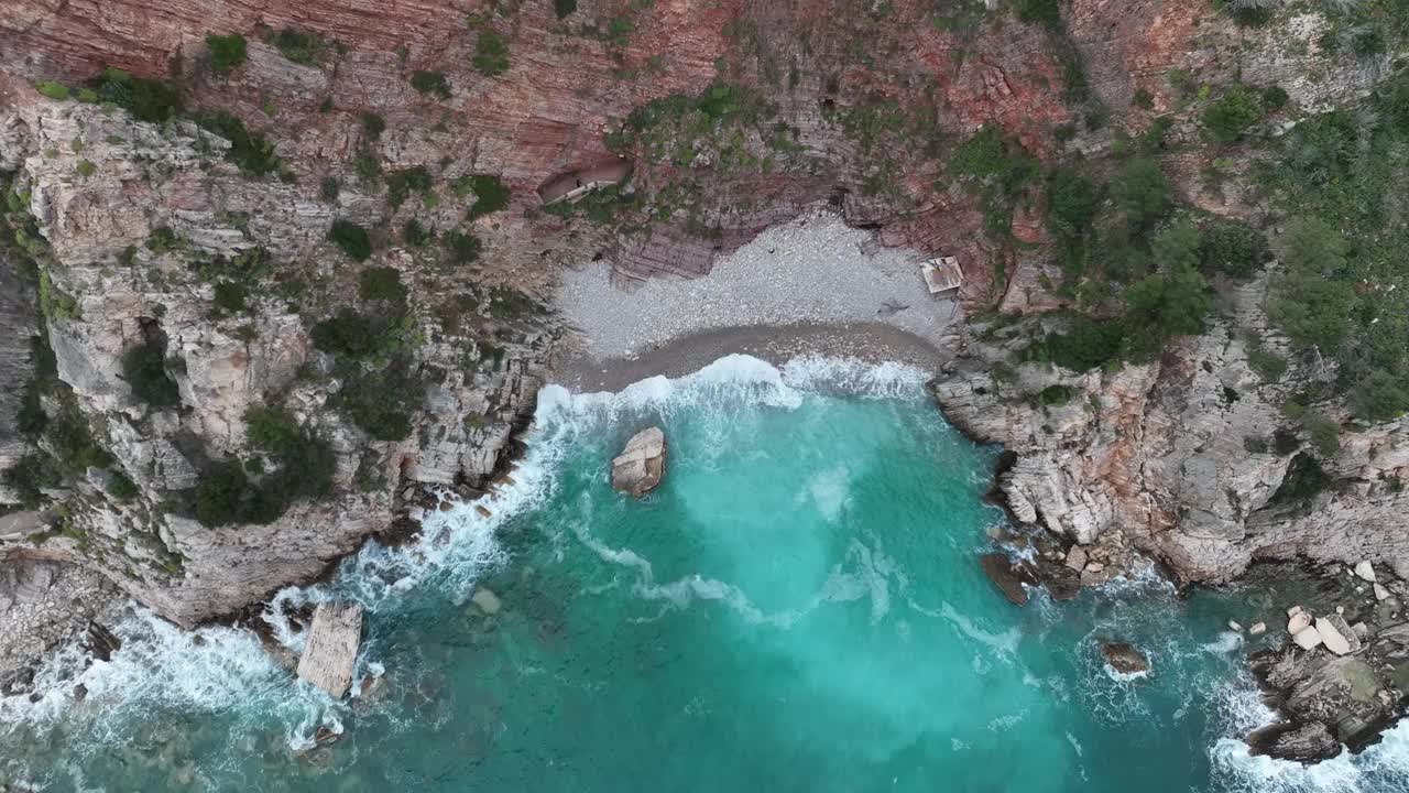 用无人机拍摄的小海滩，翠绿的海水拍打着海湾视频素材