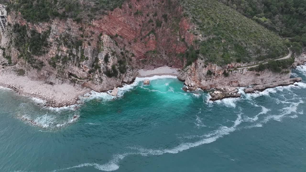 用无人机拍摄的小海滩，翠绿的海水拍打着海湾视频素材