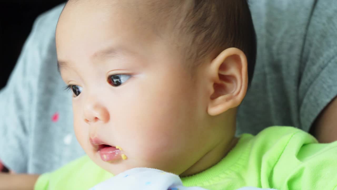 特写亚洲婴儿喂吃食物的脸。视频素材