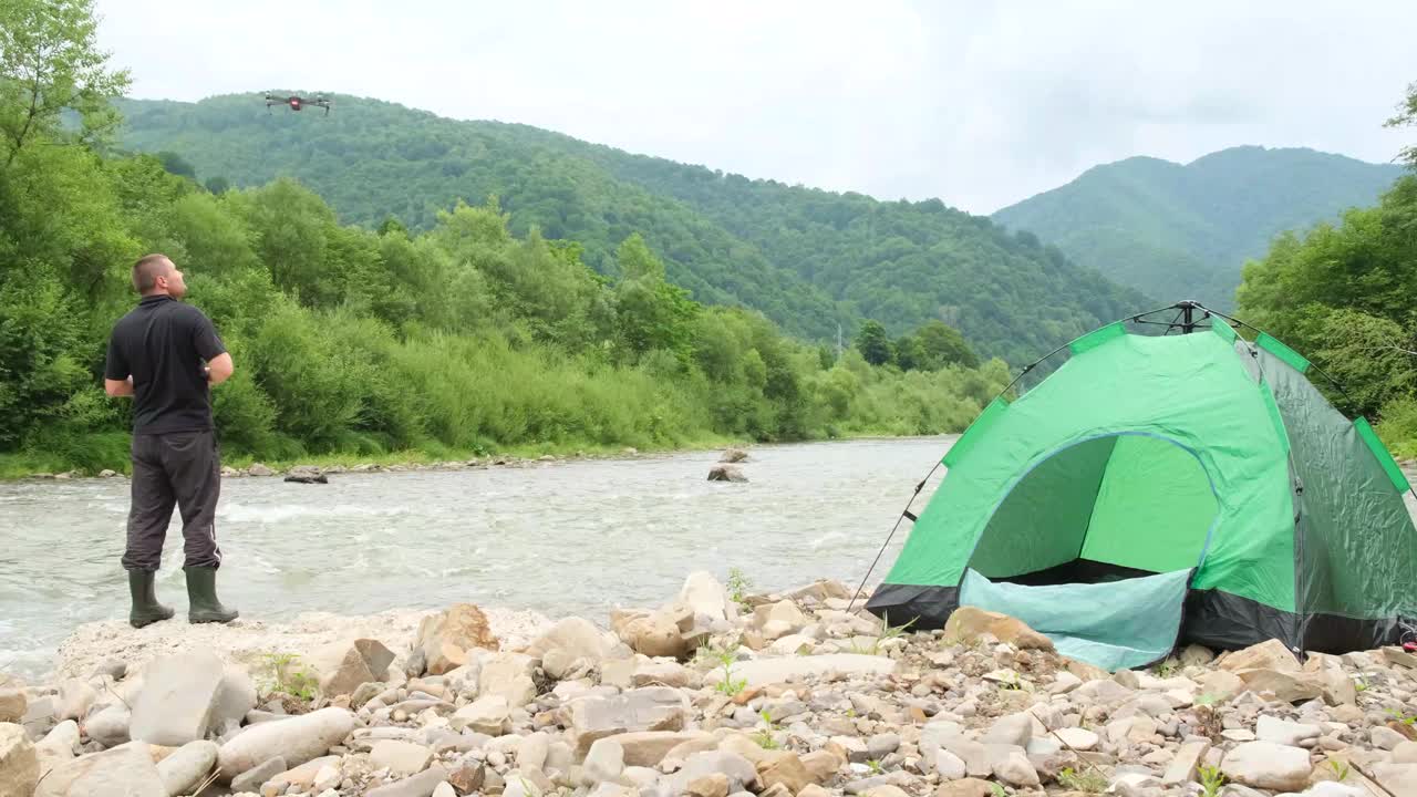 一位满意的年轻游客在山上欣赏夏日美景。视频素材