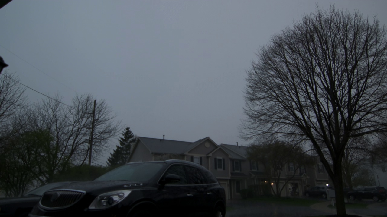 慢镜头，暴雨伴随着闪电和雨滴落在柏油路上，淹没了郊区的街道视频素材