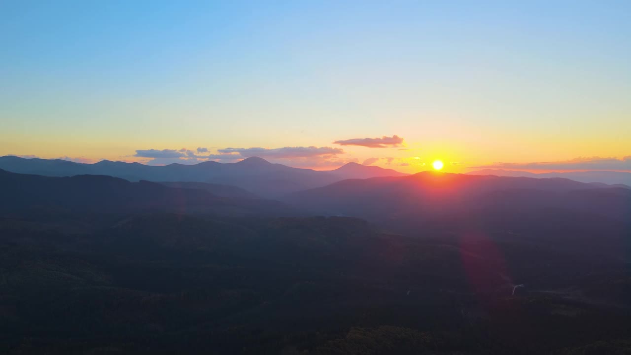 美丽的傍晚全景景观，明亮的夕阳在远处的山峰日落视频素材