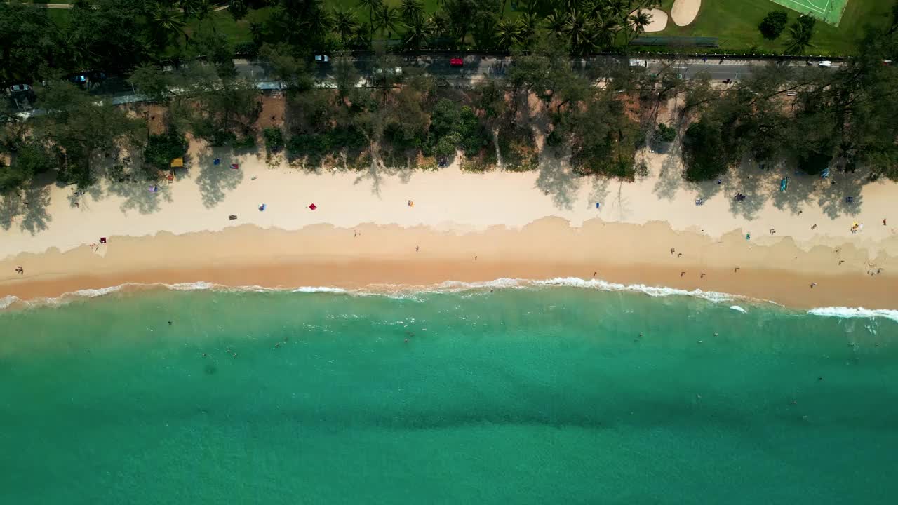 泰国普吉岛，鸟瞰大海和海滩、树木、山脉、快艇和许多在海里游泳的游客。视频下载