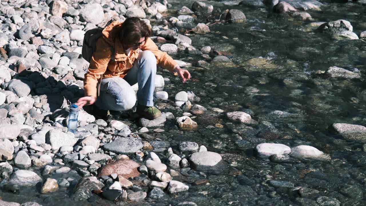 女登山客正在山河中洗手洗脸视频素材