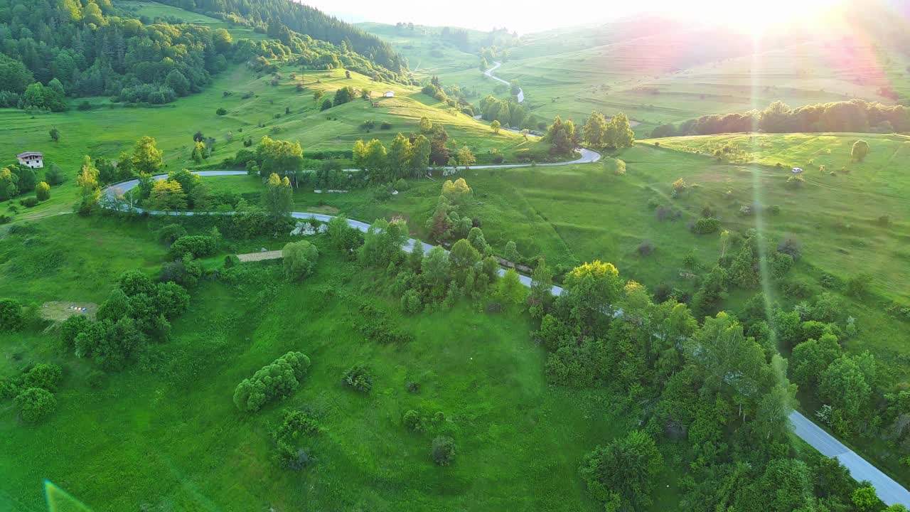 一条路经过布满云杉林和草地的山丘，天空多云视频素材