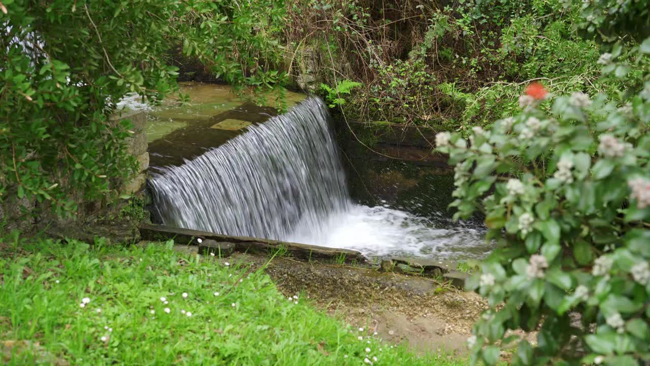 这条水道从山上下来，从阿斯图里亚斯风景如画的Cudillero村庄的一个山洞里出来。视频素材