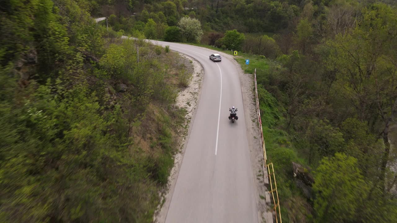 骑摩托车和汽车驾驶在开放的柏油路在阳光明媚的一天旅行概念在春天无人机鸟瞰图塞尔维亚knjazevac视频素材