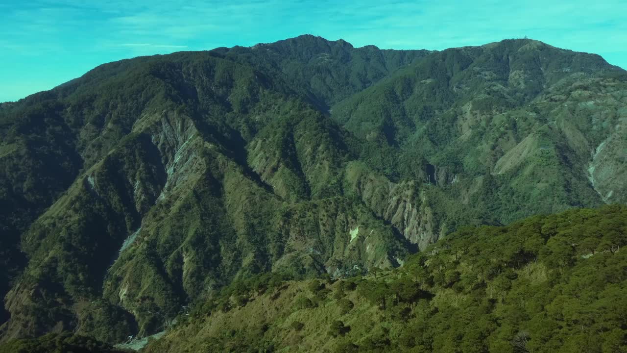 在蓝天的映衬下，高大的山脉被绿色的森林覆盖着视频素材