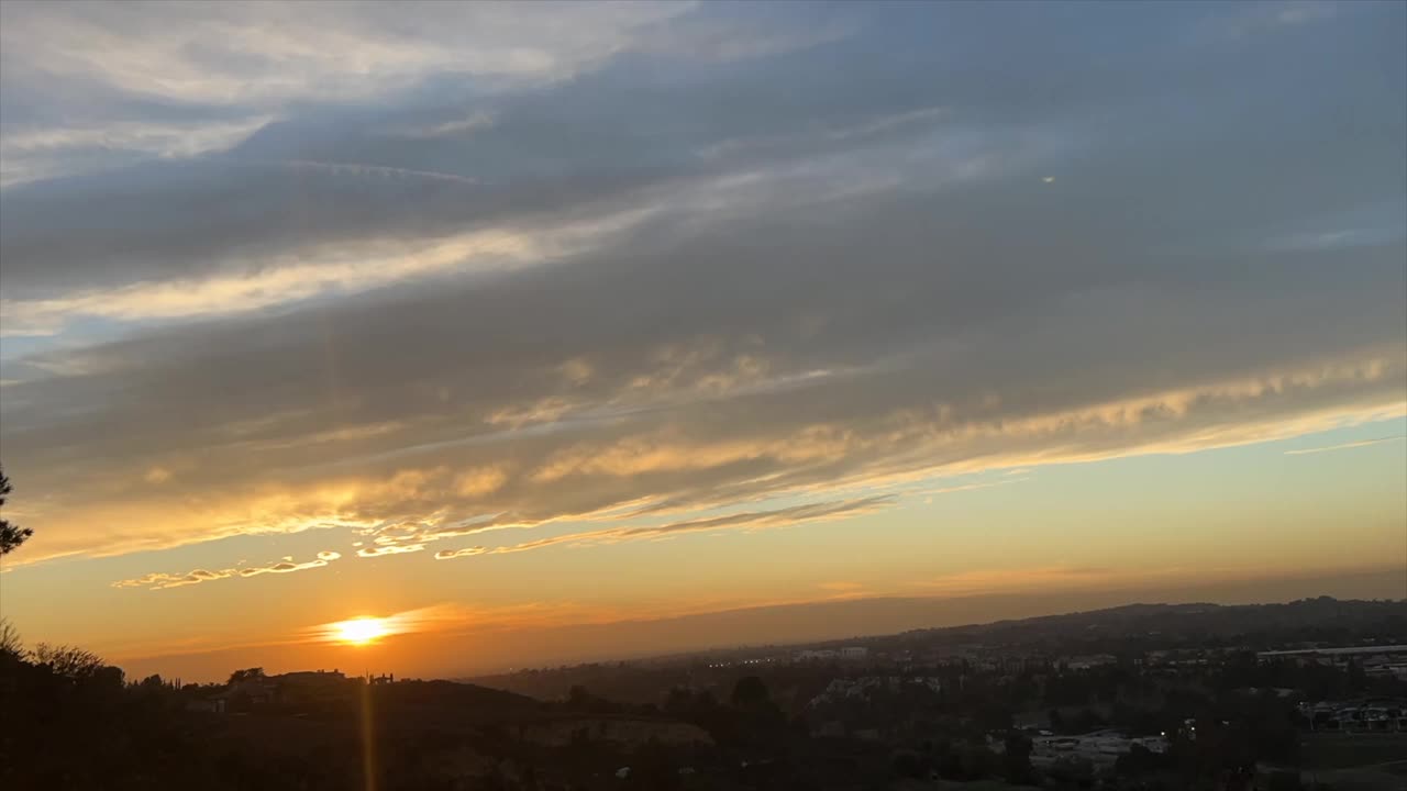 天空中云彩的时间流逝，金色的夕阳在地平线后面闪耀视频素材