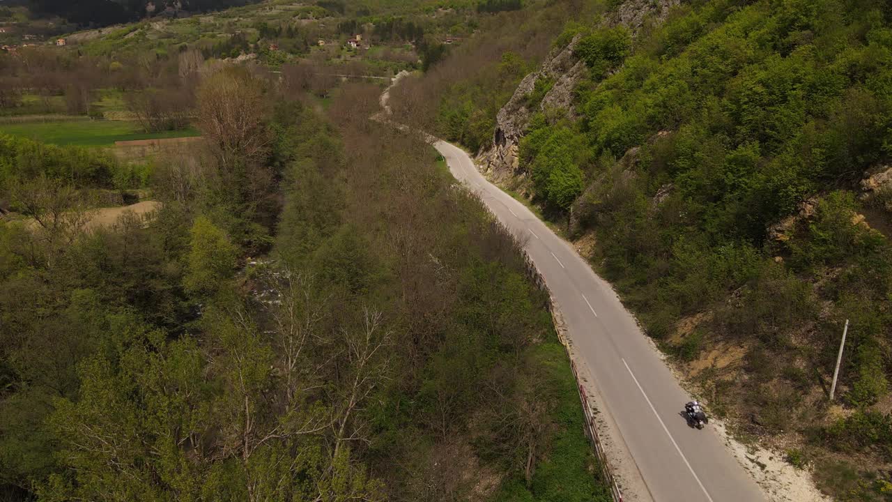 在春天晴朗的日子里，骑摩托车在开阔的道路上行驶视频素材