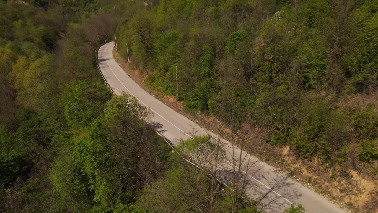 在春天晴朗的日子里，骑摩托车在开阔的道路上行驶视频素材