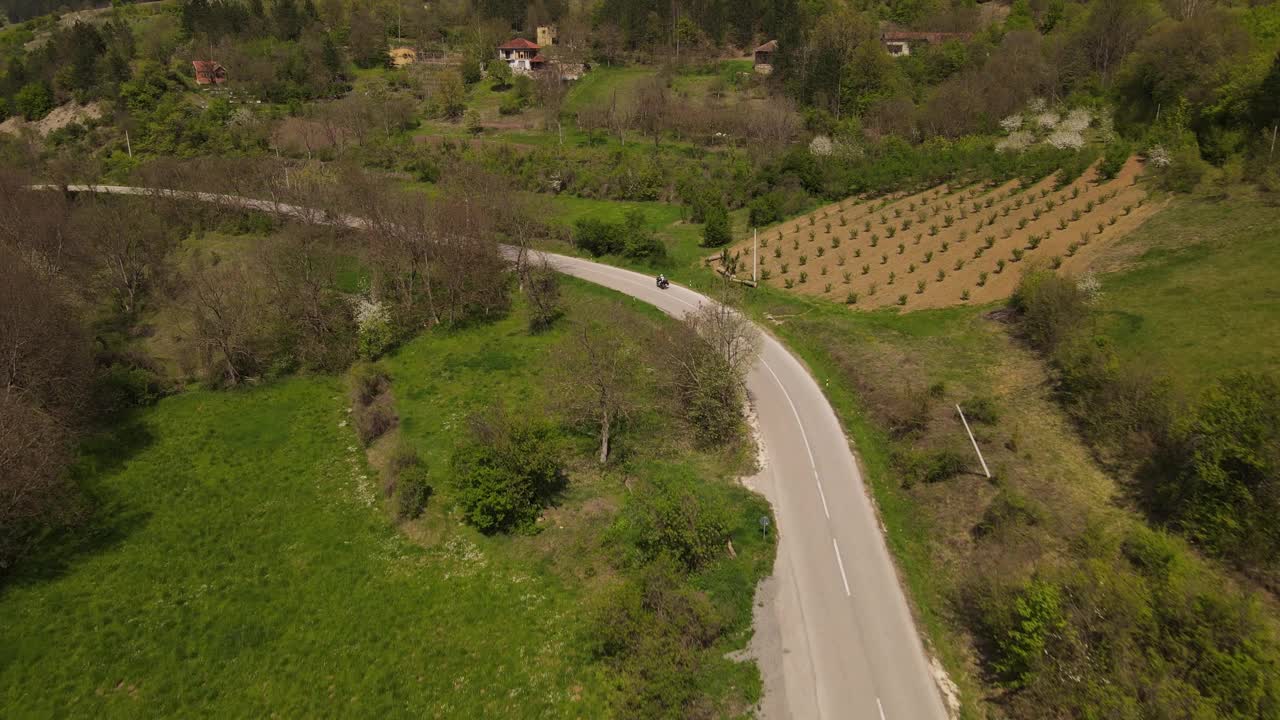 在春天晴朗的日子里，骑摩托车在开阔的道路上行驶视频素材