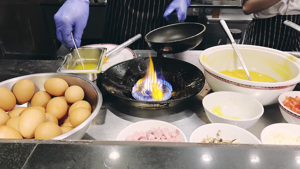 专业酒店厨师在现代餐厅厨房内往煎锅里倒油。视频素材