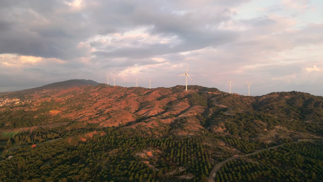 风电场中带旋转叶片的风力发电机的广角航拍图视频素材