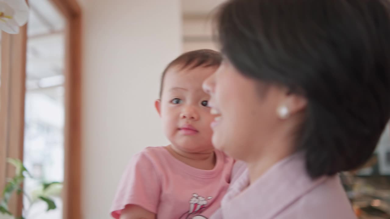 幸福的家庭，可爱的亚洲新生儿与年轻的母亲微笑幸福的脸。妈妈抱着小男孩在家里玩得很开心。为人父母，母亲节的概念。视频素材