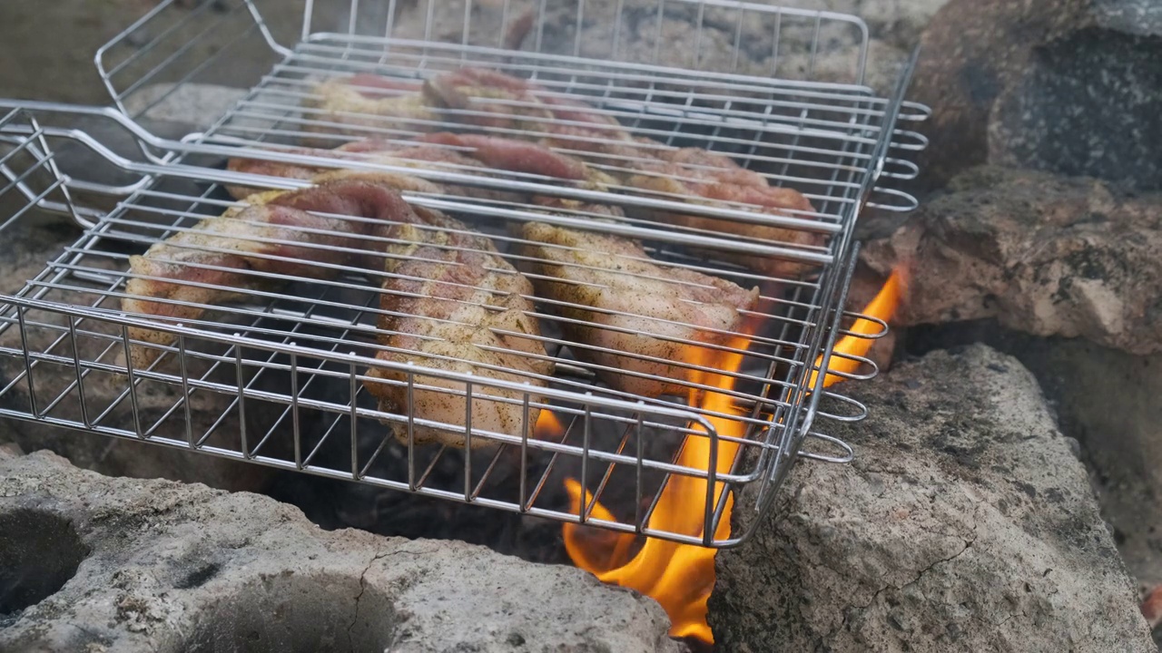 在篝火上烧烤猪肉。在室外烤架上烧烤牛肉的准备视频素材