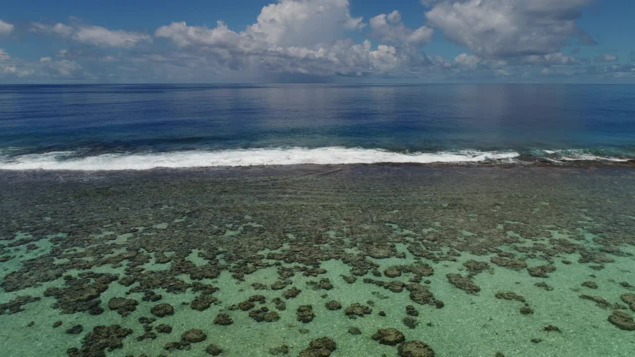 南太平洋鸟瞰图的珊瑚礁，蓝色的天空和海浪在海滩上的法属波利尼西亚，塔希提岛。视频下载