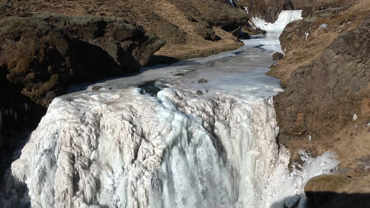 北极的自然。瀑布和冰。冰岛的冬天。冰岛冬季景观。高高的瀑布和岩石。雪和冰。是冰岛旅游的好去处。视频素材