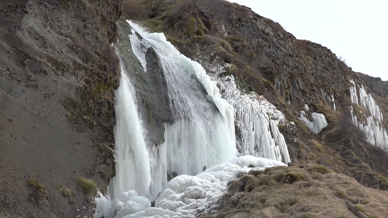 北极的自然。瀑布和冰。冰岛的冬天。冰岛冬季景观。高高的瀑布和岩石。雪和冰。是冰岛旅游的好去处。视频素材