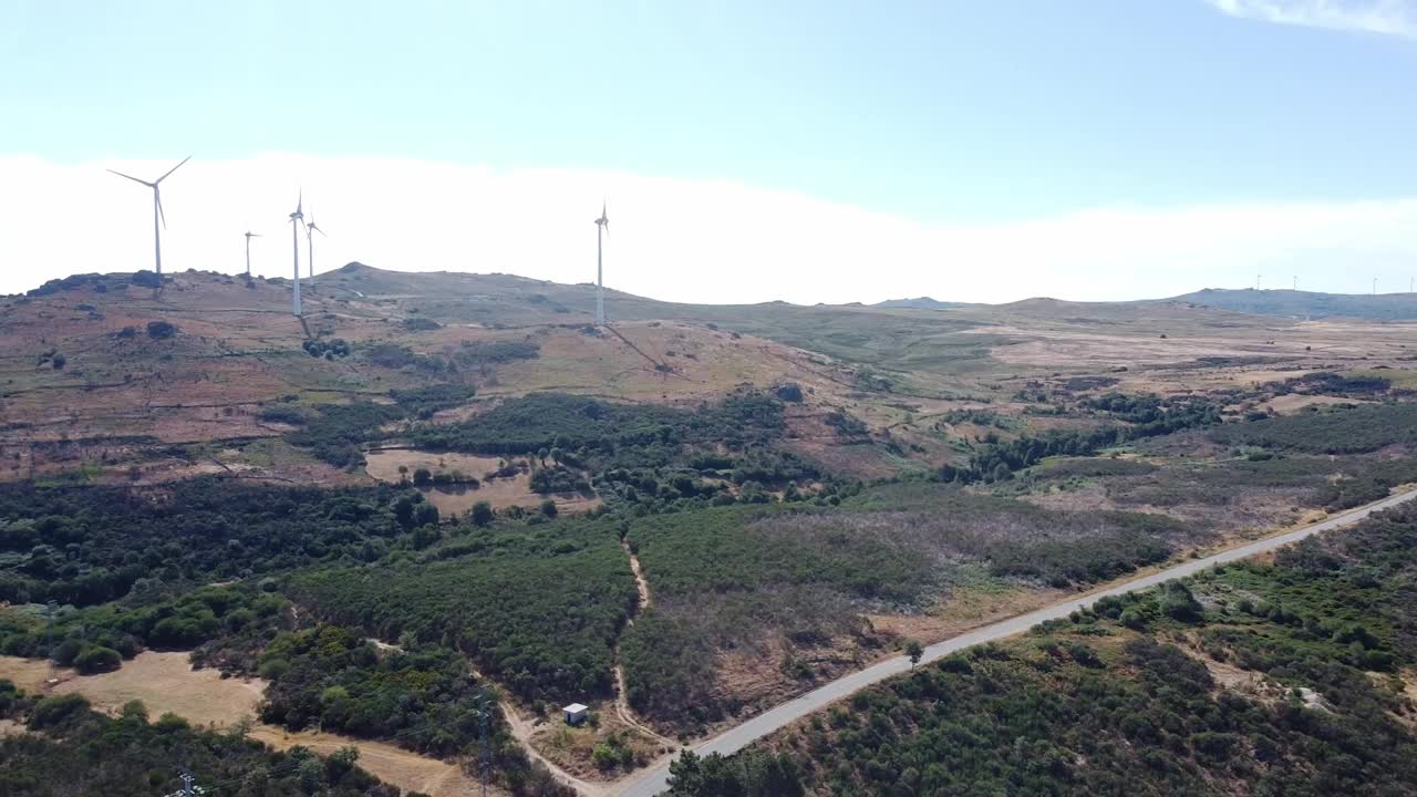 航拍视频显示，夏季道路被群山环绕，树木覆盖视频素材