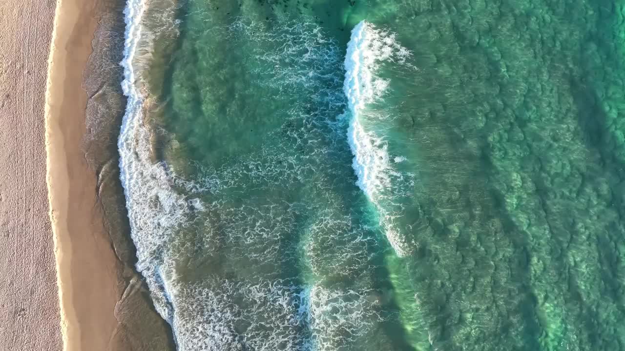 日出时海浪拍打着海滩视频素材