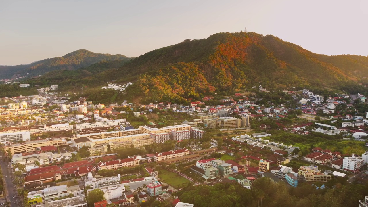 空中无人机景观的城市建立在山脚下覆盖着绿色的树木视频素材