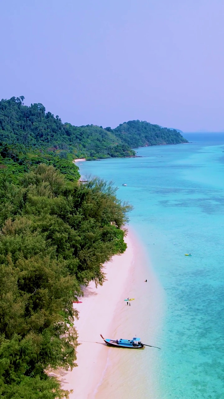 泰国南部的Koh Kradan岛，海滩上有长尾船和蓝绿色的海洋视频素材