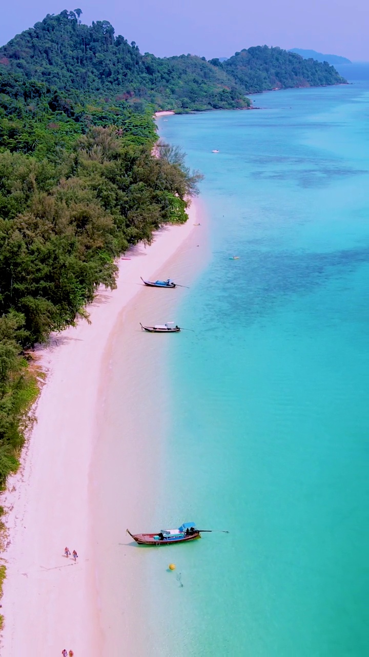 泰国南部的Koh Kradan岛，海滩上有长尾船和蓝绿色的海洋视频素材